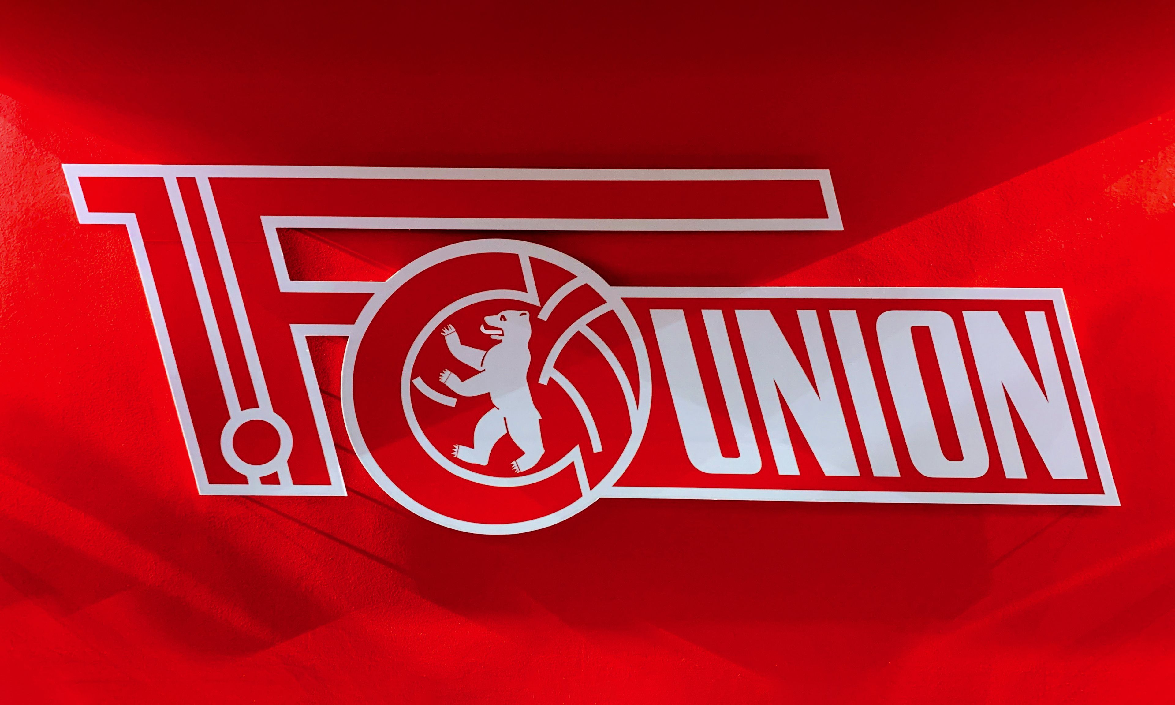 Logo des Fußballclubs 1. FC Union Berlin auf rotem Hintergrund.