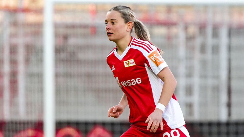 Female soccer player in a red jersey of Union Berlin, running on the field.