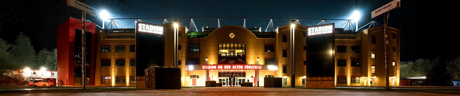 Das Bild zeigt das Stadion "Stadion der Alten Försterei" bei Nacht, beleuchtet und in seiner gesamten Fassade sichtbar.