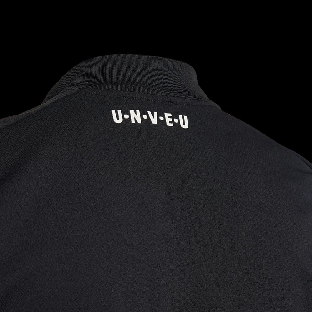 Schwarze Jacke mit weißem Schriftzug "U-N-V-E-U" auf dem Kragen.