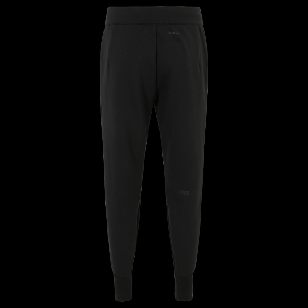 Schwarze Jogginghose. Sie hat einen elastischen Bund. Es gibt Taschen an den Seiten.