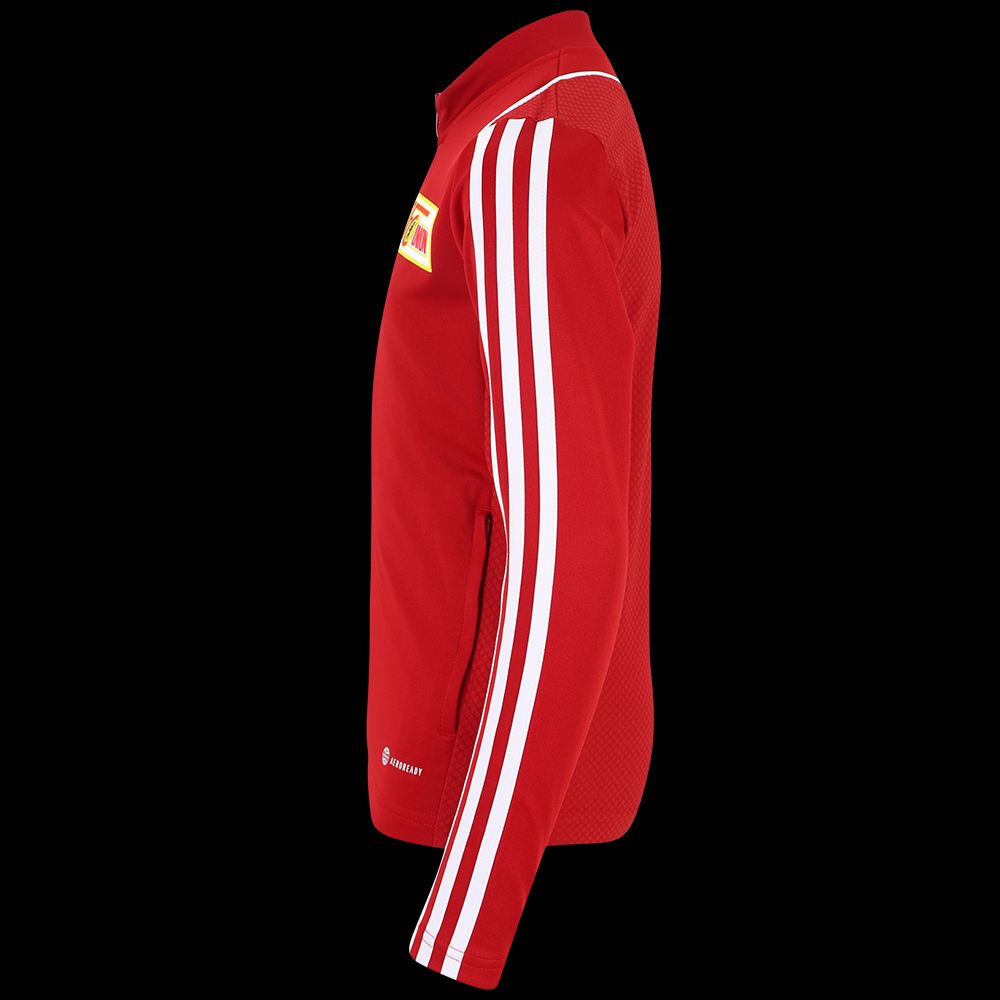 Seitenansicht einer roten Sportjacke mit weißen Streifen und einem Vereinslogo auf der Brust.