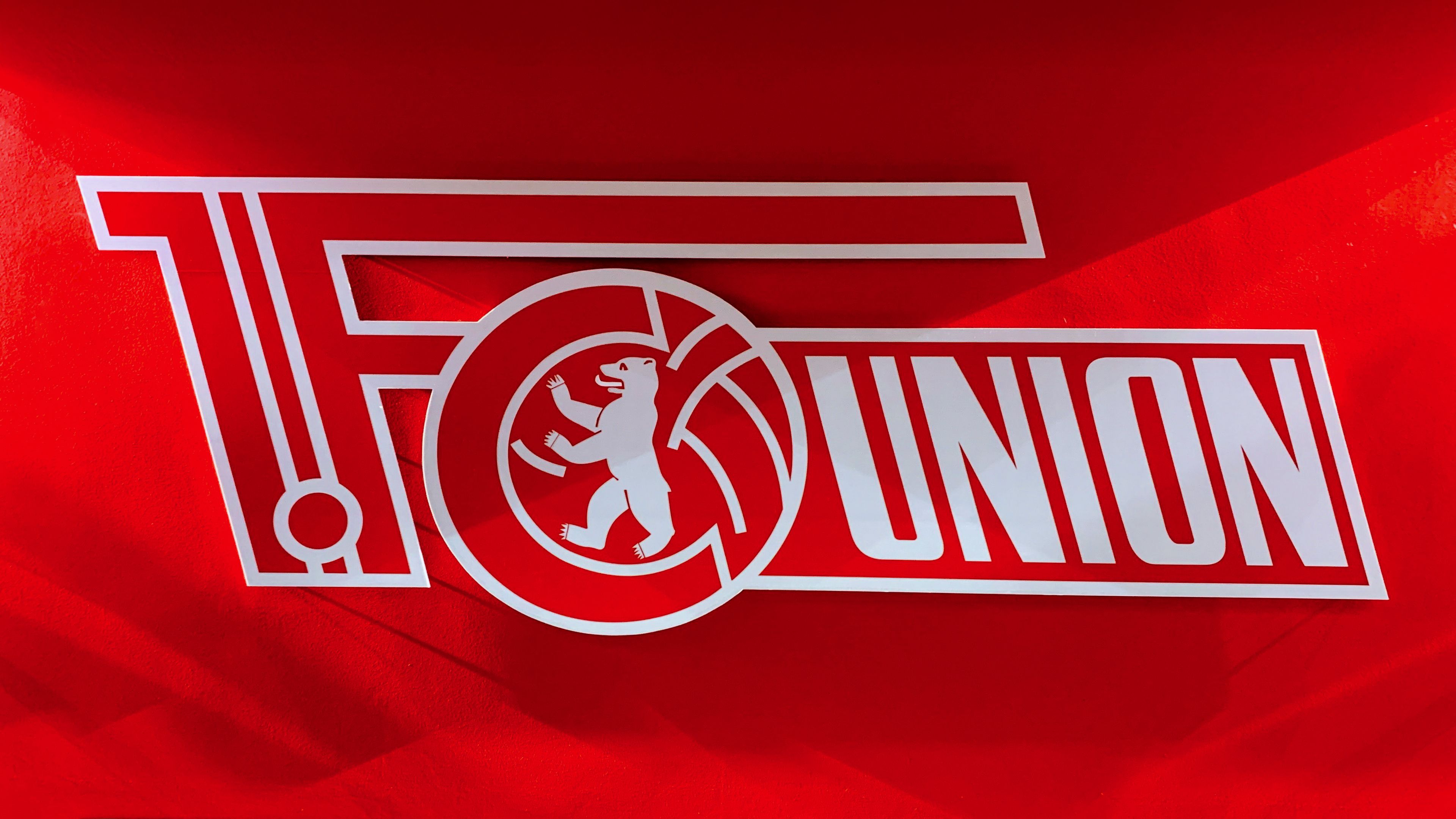 Logo des Fußballclubs 1. FC Union Berlin auf rotem Hintergrund.