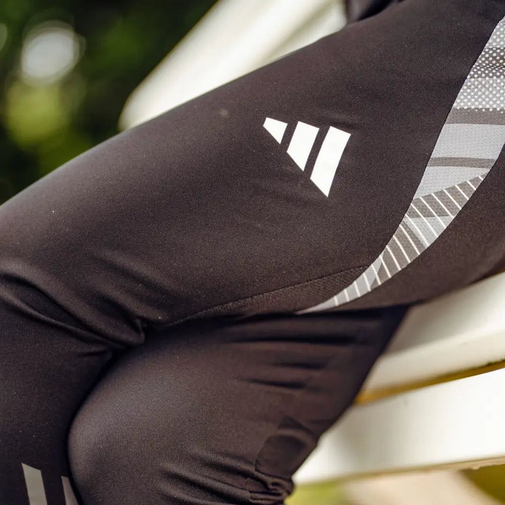 Schwarze Sportleggings mit grauen und weißen Mustern. Sie liegen auf einer Bank.