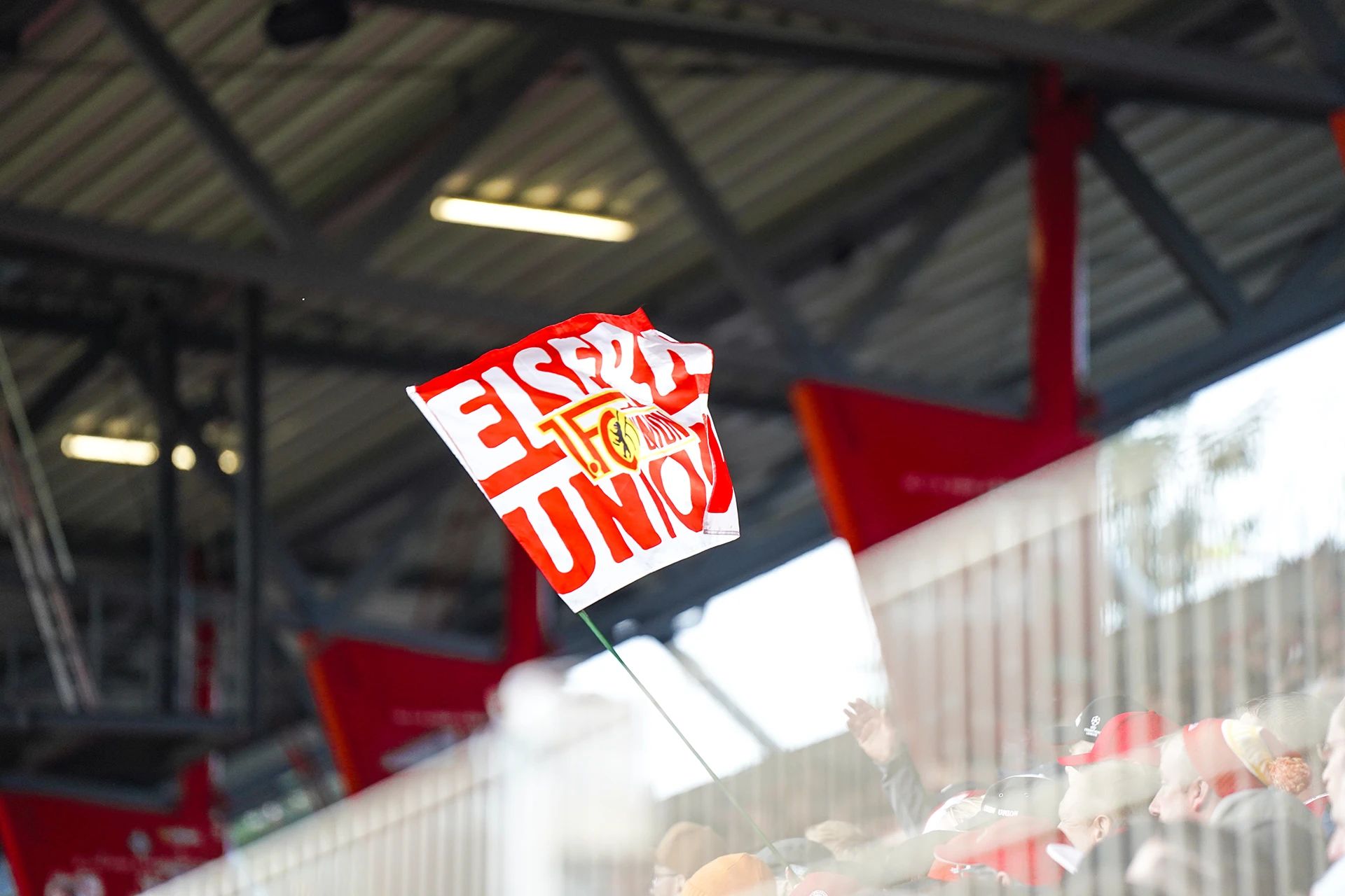 Ein rotes und weißes Flaggenbanner mit der Aufschrift "Es gibt nur Union" weht in einem Stadion voller Fans.