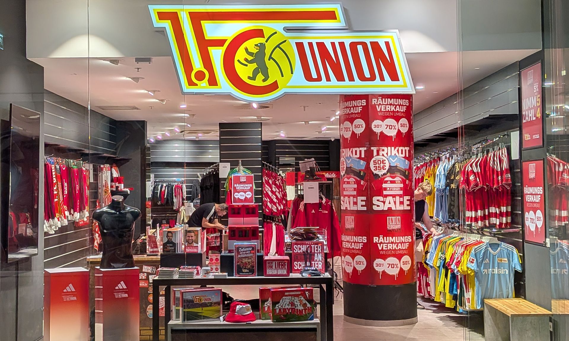 Geschäft von 1. FC Union Berlin mit Trikots, Fanartikeln und Rabattangeboten in einem sportlichen Ambiente.