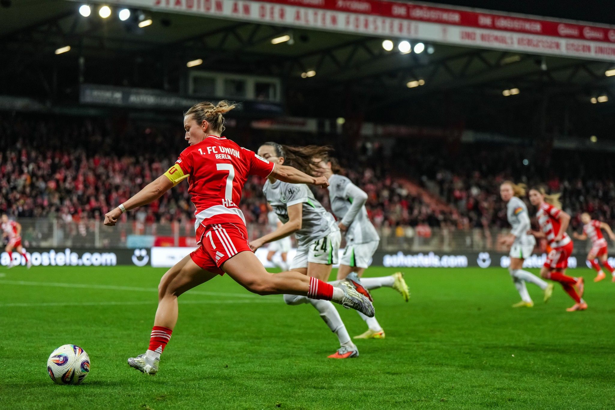 Eine Fußballspielerin des 1. FC Union Berlin schießt den Ball während eines Spiels. Im Hintergrund sind weitere Spielerinnen sichtbar.