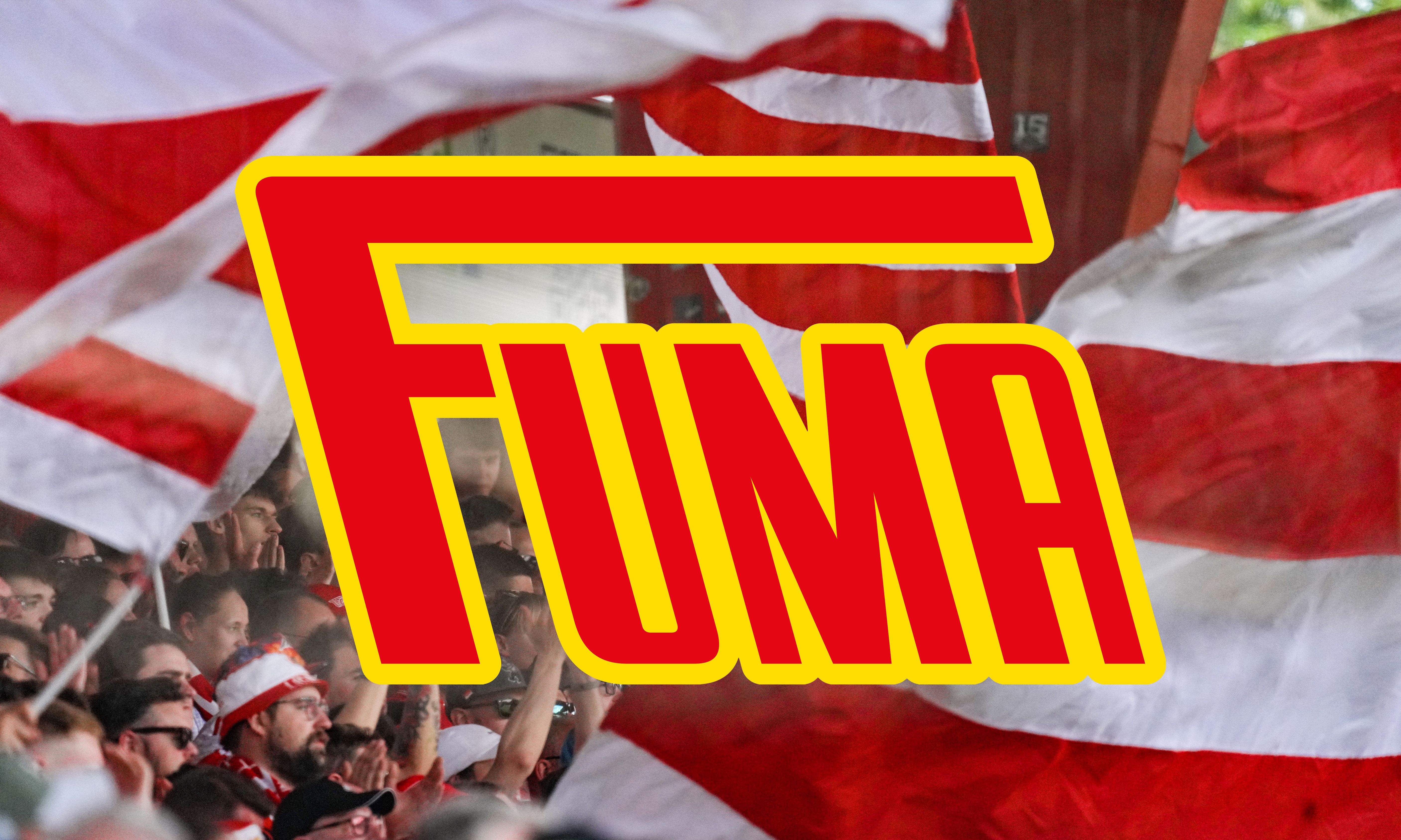 Ein begeistertes Publikum mit roten und weißen Fahnen, im Vordergrund der Schriftzug "FUMA".