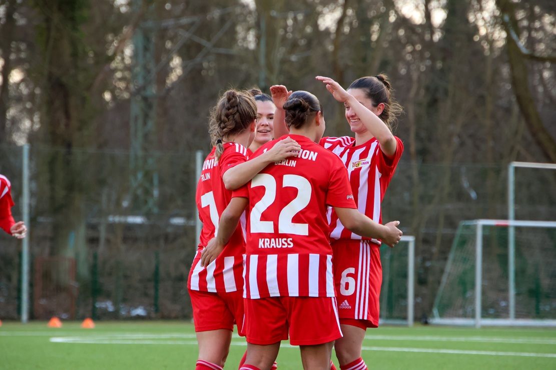Fußballspielerinnen des 1. FC Union Berlin feiern ein Tor auf dem Spielfeld.