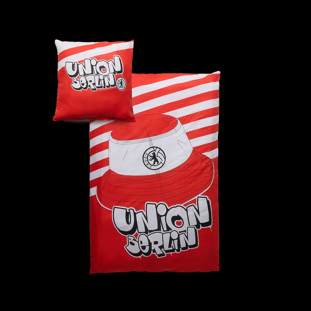 Kopfkissen und Bettwäsche mit rot-weißem Design und dem Schriftzug "Union Berlin" sowie einer grafischen Darstellung eines Huts.