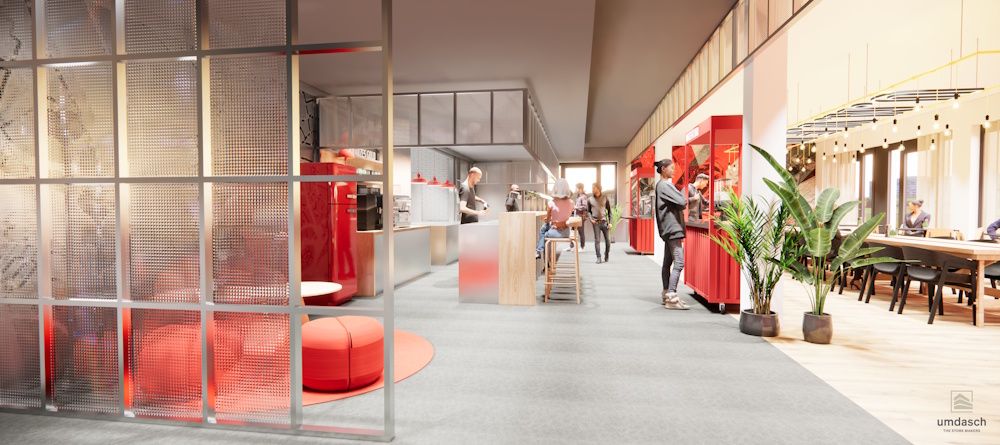 Modernes, helles Café mit roten Akzenten, Sitzbereichen und einer offenen Küche. Menschen bewegen sich im Innenraum.
