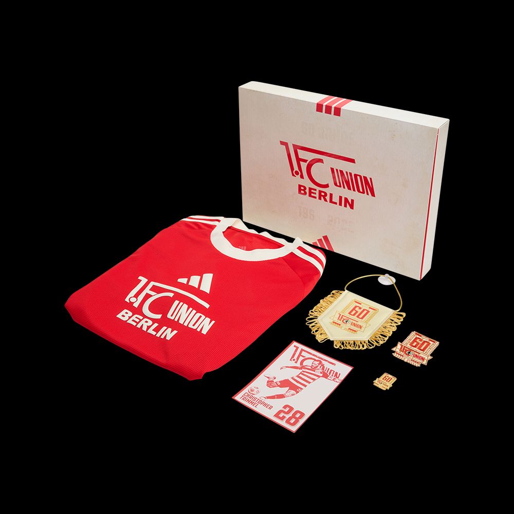 Rotes Shirt mit dem Aufdruck "1. FC UNION BERLIN" und ein Paket mit weiteren Artikeln und einer Broschüre.