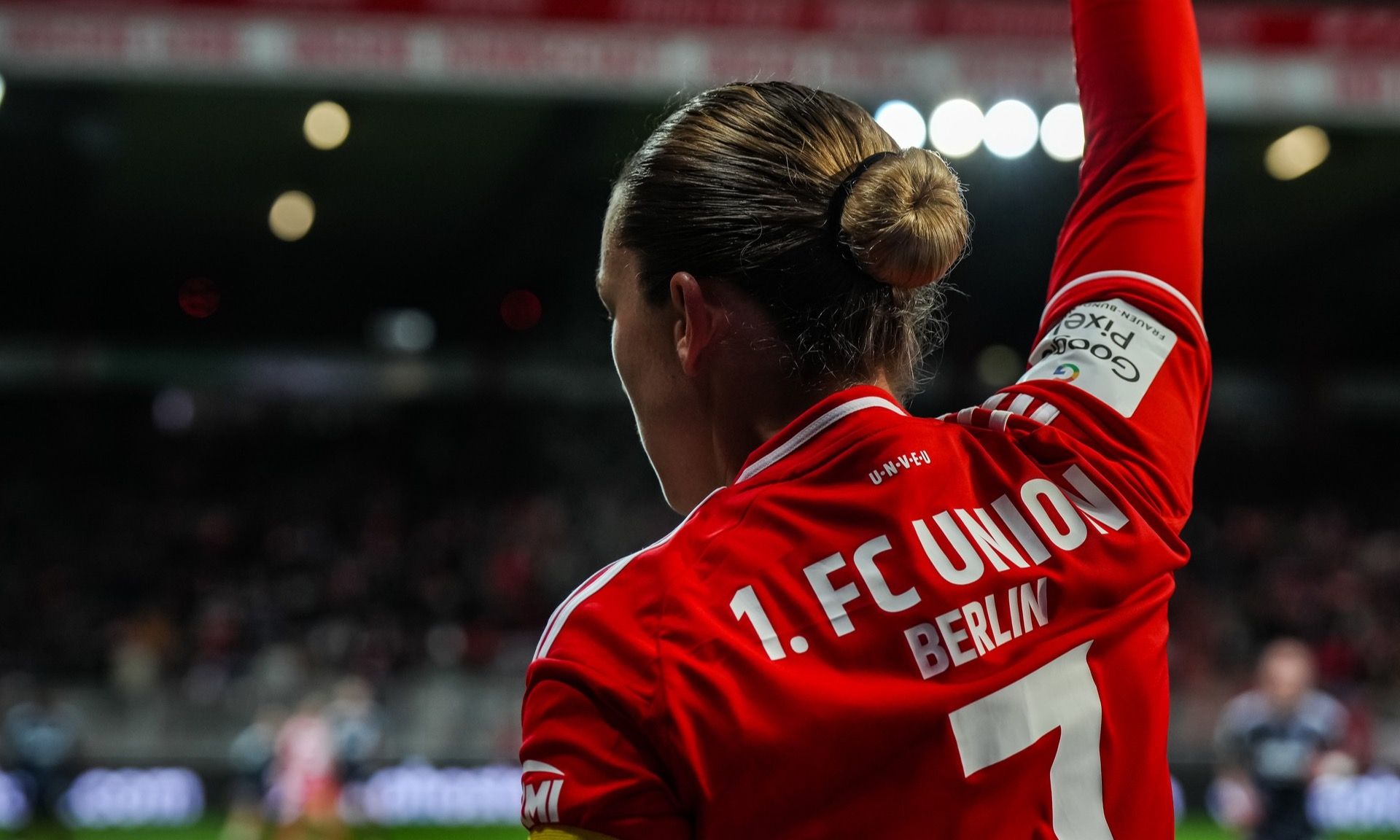 Rückansicht eines Fußballspielers mit einem rot-weißen Trikot des 1. FC Union Berlin und der Nummer 7 auf dem Rücken.